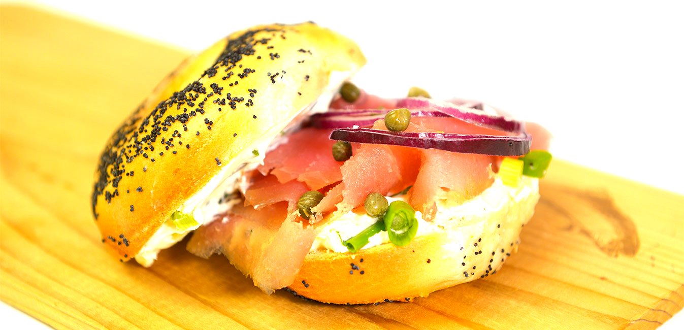 Poppy bagel stacked with nova, tomato and onion
